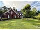 Brick home featuring a well-manicured lawn, mature trees, and a sidewalk leading to the front entrance at 4230 Berry Hill Ct, Concord, NC 28025