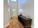 Bright foyer with hardwood floors, a decorative console table, and a view of the front door with glass panes at 4230 Berry Hill Ct, Concord, NC 28025