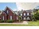Charming two-story brick home featuring black shutters, a welcoming front porch, manicured landscaping, and a lush green lawn at 4230 Berry Hill Ct, Concord, NC 28025