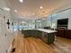Open kitchen with green cabinets, large island, and eat-in breakfast area with a view of the pool at 4230 Berry Hill Ct, Concord, NC 28025
