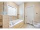 The bathroom features a soaking tub with a window, as well as tile flooring at 5052 Ashley Pl, Bessemer City, NC 28016