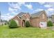 Beautiful brick home with manicured lawn, arched entrance, and two-car garage on a sunny day at 5052 Ashley Pl, Bessemer City, NC 28016