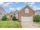 Charming brick home with well-maintained lawn, arched windows, and a two-car garage at 5052 Ashley Pl, Bessemer City, NC 28016