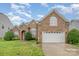 Charming brick home with well-maintained lawn, arched windows, and a two-car garage at 5052 Ashley Pl, Bessemer City, NC 28016