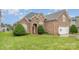 Beautiful brick home with manicured lawn, arched entrance, and two-car garage on a sunny day at 5052 Ashley Pl, Bessemer City, NC 28016