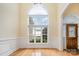 Bright foyer with hardwood floors, arched window, and decorative front door; coat rack on the wall at 5052 Ashley Pl, Bessemer City, NC 28016