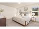 Bright bedroom featuring a large bed with stylish pillows, and a round mirror accenting the wall at 5160 Thomasville Dr # 123, Belmont, NC 28012