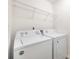 White Amana washer and dryer set with overhead wire shelving unit at 5160 Thomasville Dr # 123, Belmont, NC 28012