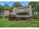 Expansive backyard features a deck, screened porch, lush lawn, mature trees and wood fence at 5233 Fairvista Dr, Charlotte, NC 28269