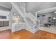 Spacious foyer with hardwood floors, white staircase, and view into the adjacent living areas at 5233 Fairvista Dr, Charlotte, NC 28269