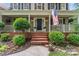 Inviting front porch with brick steps, American flag, landscaping, and decorative wreath on front door at 5233 Fairvista Dr, Charlotte, NC 28269