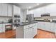 Modern kitchen with white cabinets, stainless steel appliances, a dark countertop island, and wood floors at 5233 Fairvista Dr, Charlotte, NC 28269