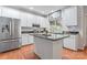 Bright kitchen with white cabinetry, stainless steel refrigerator, and a functional center island with dark countertops at 5233 Fairvista Dr, Charlotte, NC 28269