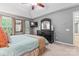 A spacious main bedroom featuring a tray ceiling, fan, and a well-lit dressing area at 5233 Fairvista Dr, Charlotte, NC 28269