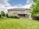 Expansive backyard view featuring a patio, manicured lawn, and mature trees at 538 Fairwoods Dr, Huntersville, NC 28078