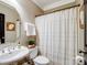 Well-lit half bath with a pedestal sink, decorative mirror, and toilet with a curtain at 538 Fairwoods Dr, Huntersville, NC 28078