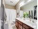 Well-lit bathroom with double vanity, decorative mirror and tub with shower at 538 Fairwoods Dr, Huntersville, NC 28078