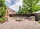 Outdoor fire pit with a circular stone surround and beautiful landscaping at 538 Fairwoods Dr, Huntersville, NC 28078