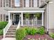 Inviting front porch with stone accents, white columns, and lush greenery for a welcoming entrance at 538 Fairwoods Dr, Huntersville, NC 28078
