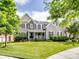 Charming two-story home featuring a well-manicured lawn, mature trees, and inviting front porch at 538 Fairwoods Dr, Huntersville, NC 28078