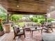 An outdoor covered patio with comfortable seating offers an ideal space for relaxation and entertaining with a view of a landscaped yard at 538 Fairwoods Dr, Huntersville, NC 28078