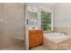 Bathroom featuring a tiled shower with glass door, a tub and a wooden vanity at 6655 Maple Spring Ct, Denver, NC 28037