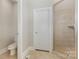 Bathroom with toilet and tiled shower with glass door, all in neutral colors at 6655 Maple Spring Ct, Denver, NC 28037