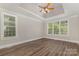 This bedroom offers neutral paint, dark laminate floors, and plenty of natural light at 6655 Maple Spring Ct, Denver, NC 28037