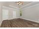 This bedroom features neutral paint, dark laminate floors, and a tray ceiling at 6655 Maple Spring Ct, Denver, NC 28037