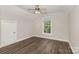This bedroom has beautiful dark laminate floors, neutral paint, and a ceiling fan at 6655 Maple Spring Ct, Denver, NC 28037
