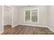 Well-lit bedroom with hardwood floors, neutral walls, white trim, closet and single window at 6655 Maple Spring Ct, Denver, NC 28037