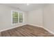 Well-lit bedroom with hardwood floors, neutral walls, white trim and single window at 6655 Maple Spring Ct, Denver, NC 28037
