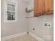 A functional laundry area has a window and overhead cabinets for storage at 6655 Maple Spring Ct, Denver, NC 28037