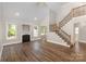 Spacious living room with hardwood floors, fireplace, and natural light from multiple windows at 6655 Maple Spring Ct, Denver, NC 28037
