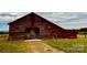 A rustic, red barn is nestled in a green field under a cloudy sky, with visible hay storage inside at 6714 Old Shelby Rd, Vale, NC 28168
