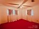 Bedroom featuring a ceiling fan and sheer curtains with red carpet at 6714 Old Shelby Rd, Vale, NC 28168
