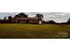 A single-story brick home with an attached garage, featuring a sprawling lawn and a barn in the background at 6714 Old Shelby Rd, Vale, NC 28168