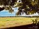 Scenic grassy field showcases rural charm with distant mountains and mature tree line in a peaceful landscape at 6714 Old Shelby Rd, Vale, NC 28168