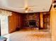 Cozy living room featuring a brick fireplace, wood paneling, and sliding glass doors to the outside at 6714 Old Shelby Rd, Vale, NC 28168