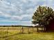 Scenic view of a field with a rustic fence, lush grass, and trees at 6714 Old Shelby Rd, Vale, NC 28168