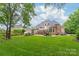 Sprawling backyard featuring a large lawn, patio, fire pit, outdoor kitchen, and lush landscaping for entertainment at 7018 Dowington Dr, Charlotte, NC 28277