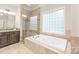This bathroom boasts a jacuzzi tub and walk-in shower with glass-block accents and tile surround at 7018 Dowington Dr, Charlotte, NC 28277