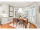 Sun-drenched dining area features a modern chandelier, bright windows, and convenient kitchen access at 7018 Dowington Dr, Charlotte, NC 28277