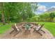 Charming fire pit area with Adirondack chairs, lush greenery, and a serene setting for cozy outdoor gatherings at 7018 Dowington Dr, Charlotte, NC 28277