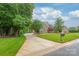 Traditional brick home with manicured front lawn and a long, winding driveway at 7018 Dowington Dr, Charlotte, NC 28277