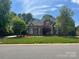 Charming brick home with lush green lawn and manicured landscaping, perfect for curb appeal at 7018 Dowington Dr, Charlotte, NC 28277