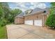 Brick house exterior featuring a large driveway leading to a spacious two-car garage at 7018 Dowington Dr, Charlotte, NC 28277