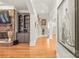 Elegant hallway with hardwood floors, a staircase, built-in shelving, and tasteful décor, creating a seamless flow at 7018 Dowington Dr, Charlotte, NC 28277