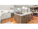 Open kitchen design with a central island, stainless appliances, wine cooler, and a sunlit dining area at 7018 Dowington Dr, Charlotte, NC 28277