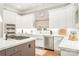 Well-lit kitchen featuring stainless steel appliances, gas cooktop, white cabinets, and farmhouse sink at 7018 Dowington Dr, Charlotte, NC 28277